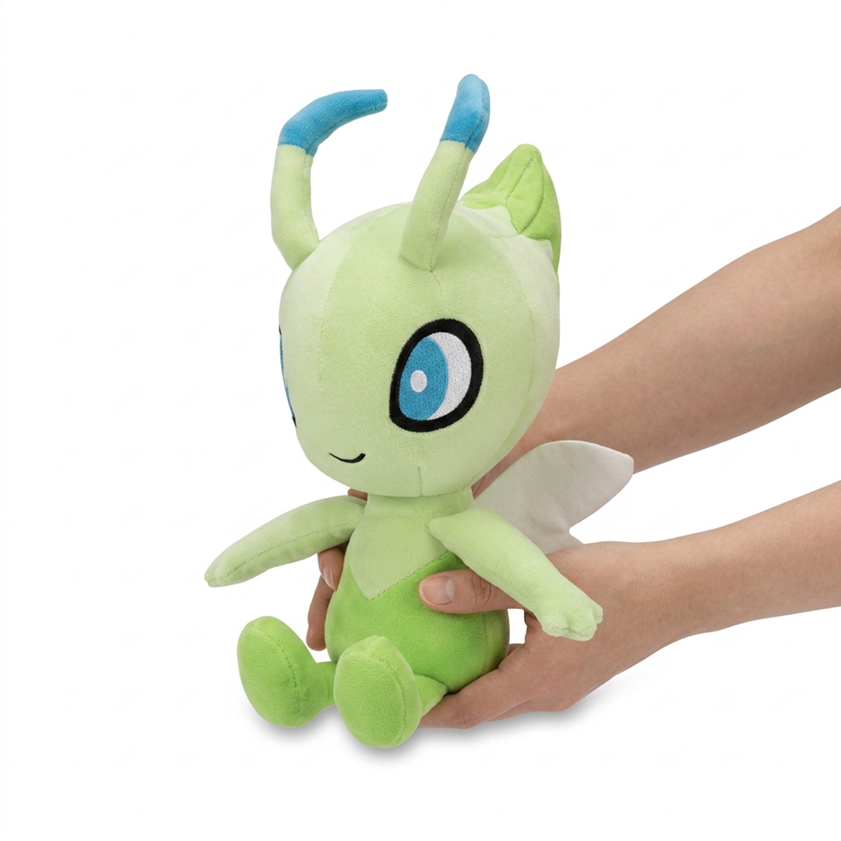 Peluche Celebi tenue dans les mains