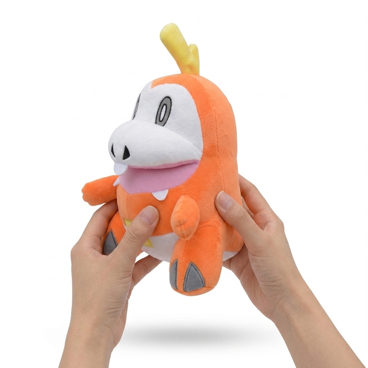 Peluche Chochodile tenue dans les mains