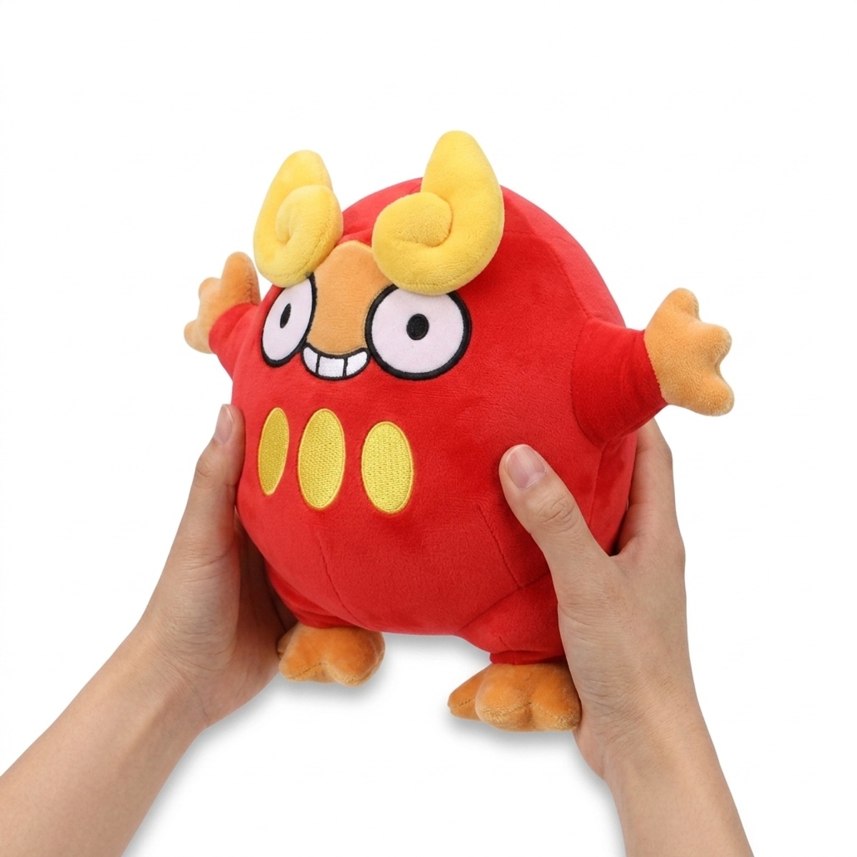 Peluche Darumarond tenue dans les mains