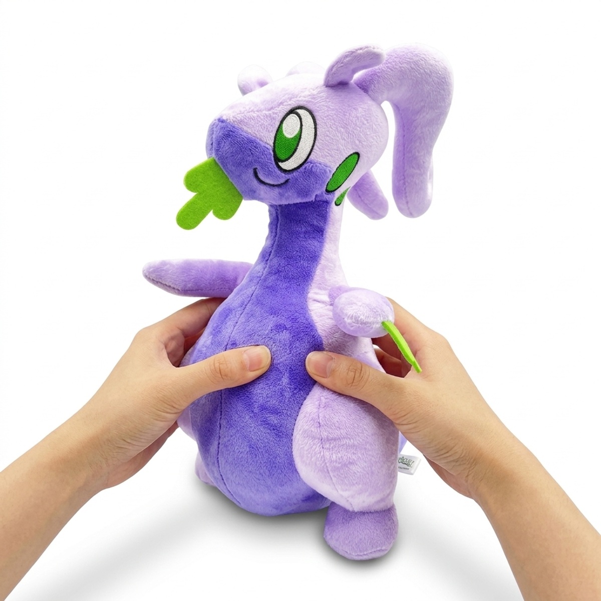 Peluche Muplodocus tenue dans les mains