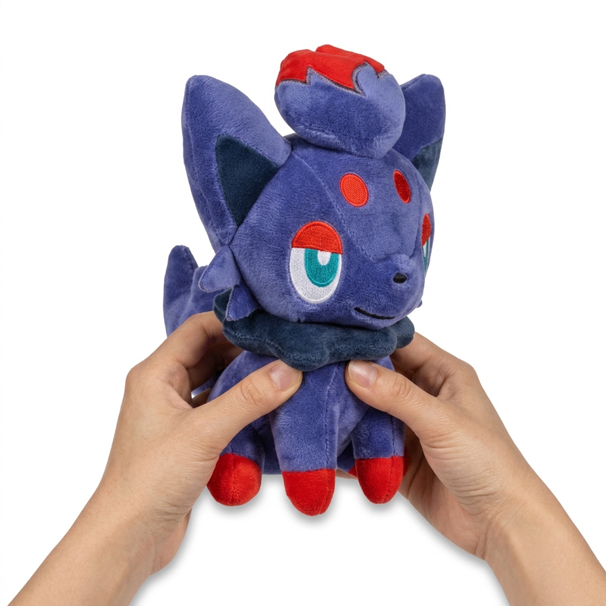 Peluche Zorua tenue dans les mains